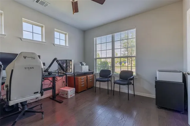 a view of a workspace with furniture and a window