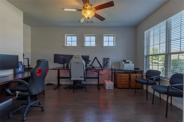 a living room with furniture a desk and chair with windows