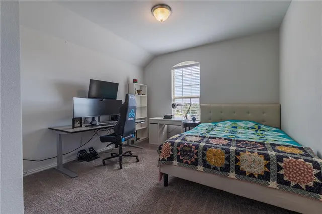 a bedroom with a bed and a computer on a desk