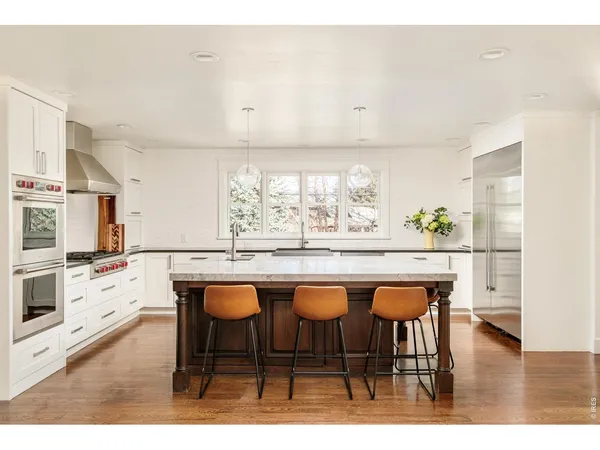a dining hall with stainless steel appliances kitchen island granite countertop a stove a sink and a refrigerator
