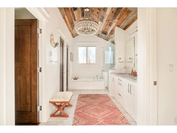 a spacious bathroom with a granite countertop sink a mirror and a bathtub