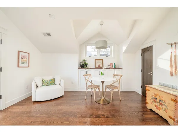 a dining room with furniture and wooden floor