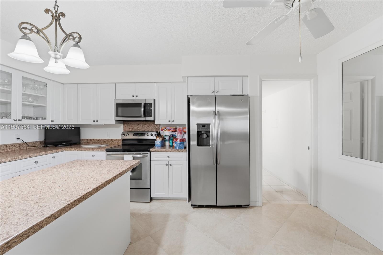 19670 South Beach Road, Unit B323 Tequesta, FL 33469 - Photo 13 of 57 a kitchen with stainless steel appliances granite countertop a refrigerator a stove a sink dishwasher and a refrigerator with white cabinets