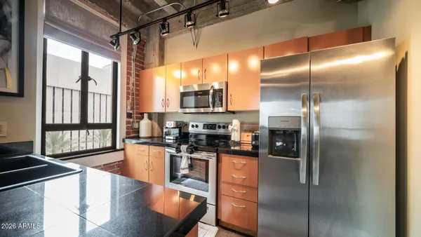 a kitchen with stainless steel appliances granite countertop a stove a refrigerator and a sink