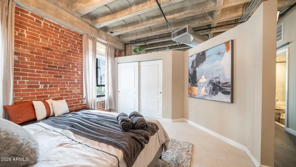 a bedroom with a bed and a painting on the wall