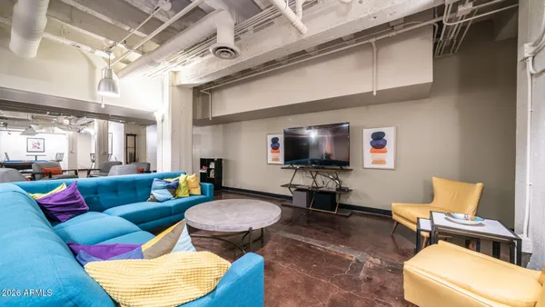 a living room with patio chairs and a dining table with wooden floor