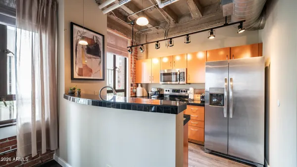 a kitchen with stainless steel appliances a refrigerator a sink a stove and cabinets