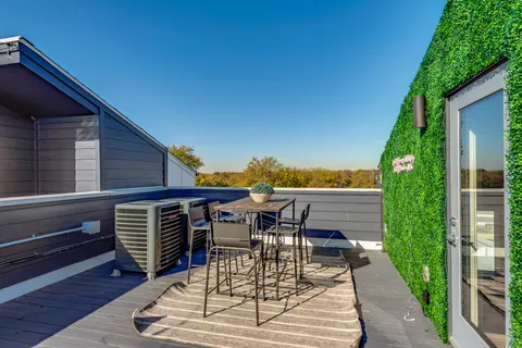 a view of a patio with table and chairs with wooden floor and fence