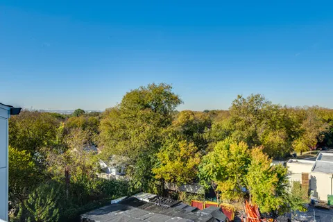 a living room with furniture wooden floor and a large window