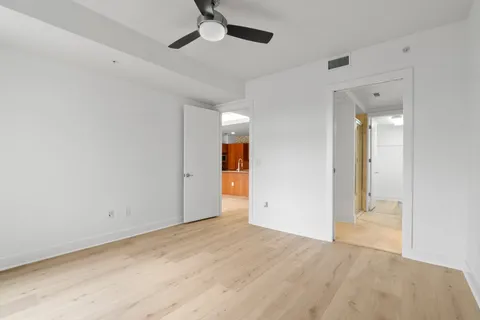 an empty room with fan and entrance