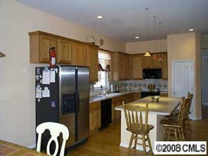 1610 Spandril Lane Fort Mill, SC 29708 - Photo 4 of 8 a kitchen with a table chairs refrigerator and microwave