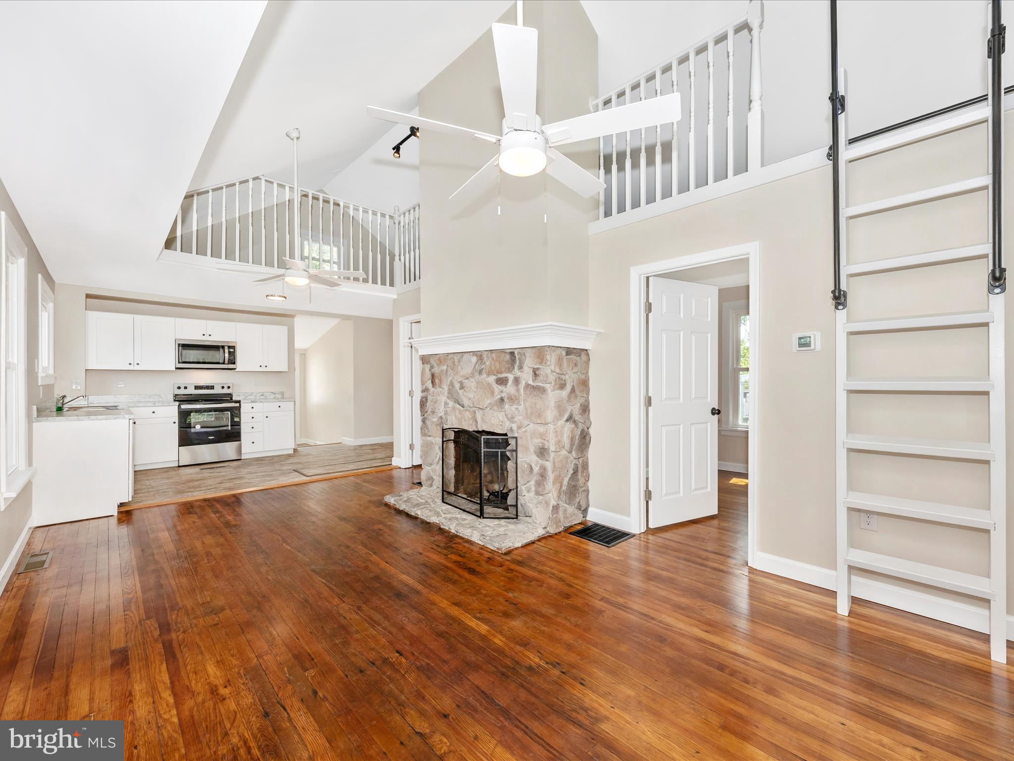 a view of a livingroom with a fireplace a chandelier and entryway