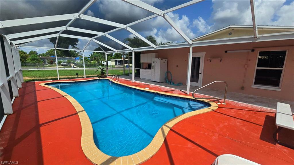 10 East Jersey Road Lehigh Acres, FL 33936 - Photo 2 of 7 Swimming pool with a patio, glass enclosure, and a sunroom