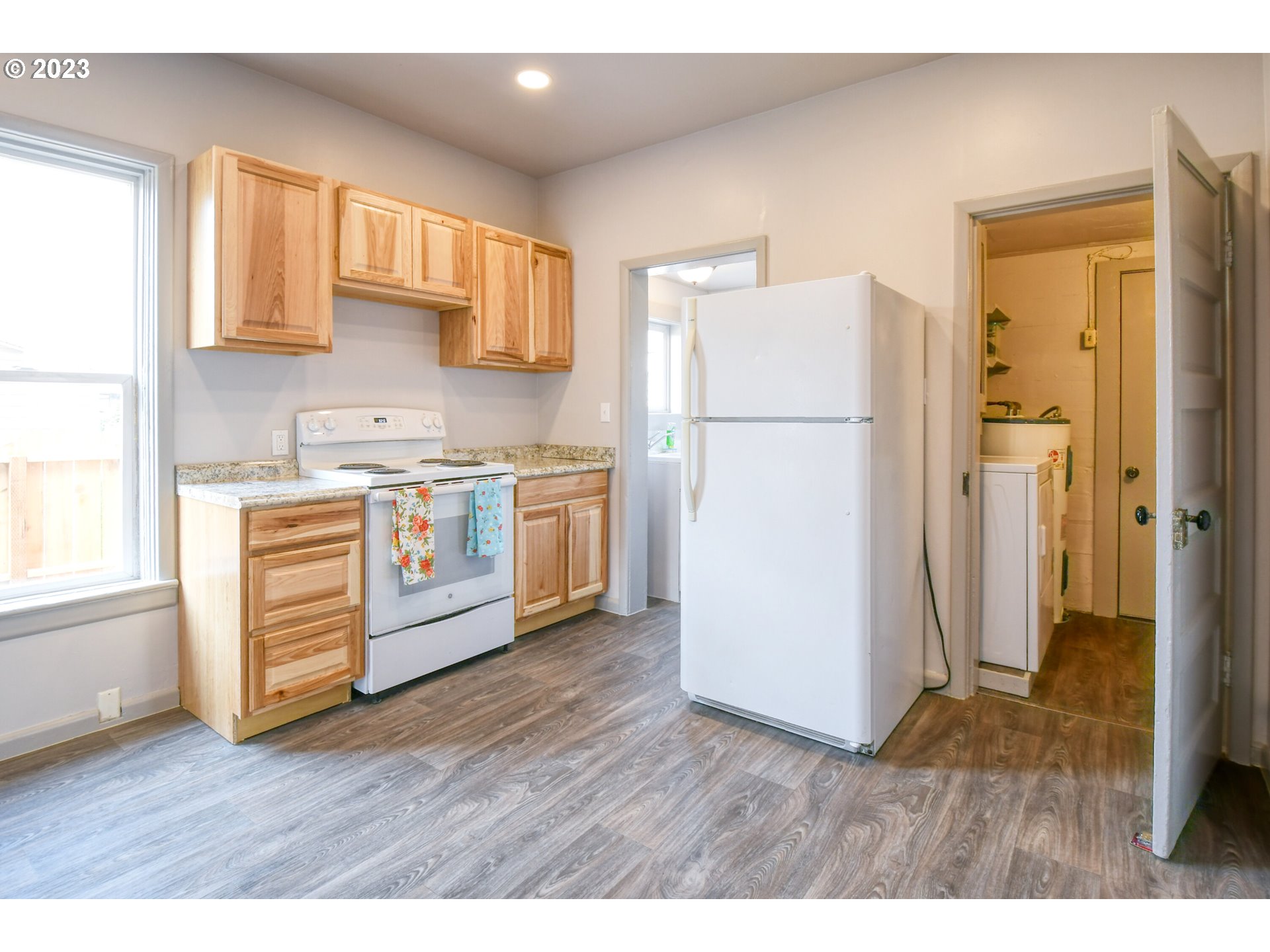 408 Southwest 8th Street Pendleton, OR 97801 - Photo 8 of 30 a kitchen with a refrigerator a stove a microwave and wooden floor