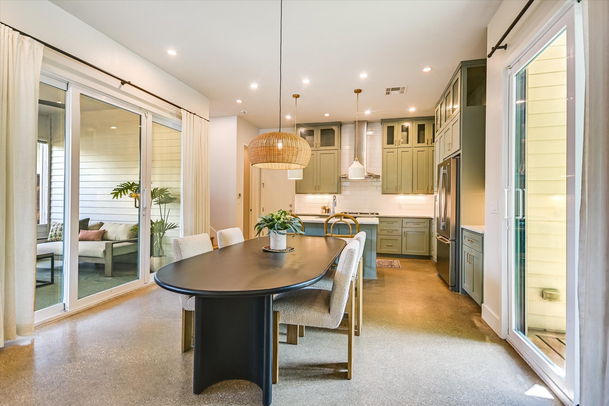 1605 Hether Street Austin, TX 78704 - Photo 10 of 26 Open-concept kitchen and dining area featuring concrete-finish flooring, recessed lighting, and a woven pendant light fixture