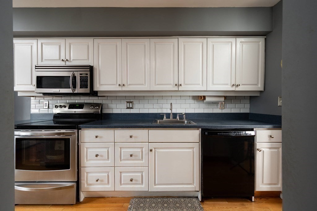 12 Spinnaker Hill Lane, Unit 12 Hull, MA 02045 - Photo 12 of 39 a kitchen with granite countertop white cabinets and stainless steel appliances