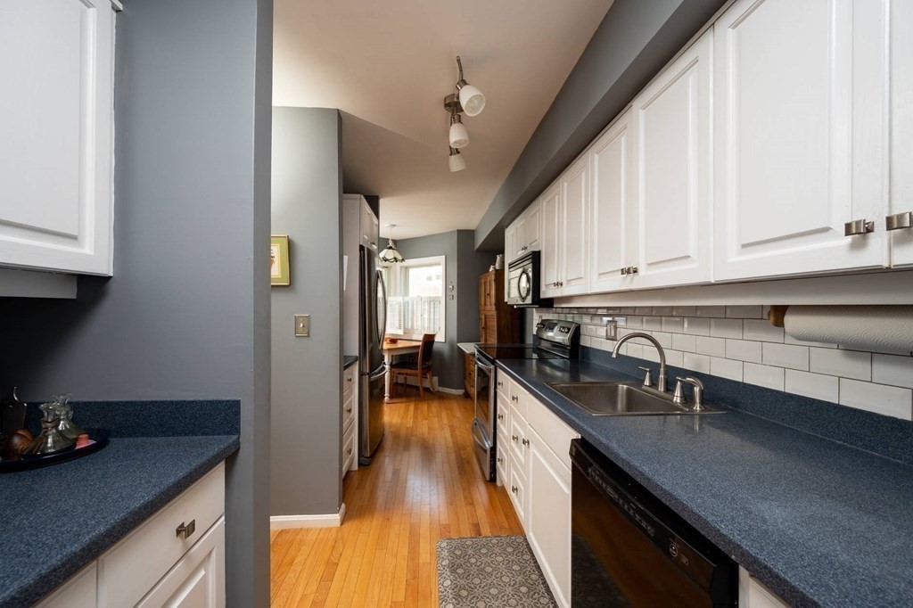 12 Spinnaker Hill Lane, Unit 12 Hull, MA 02045 - Photo 13 of 39 a kitchen with stainless steel appliances granite countertop a sink a stove and cabinets