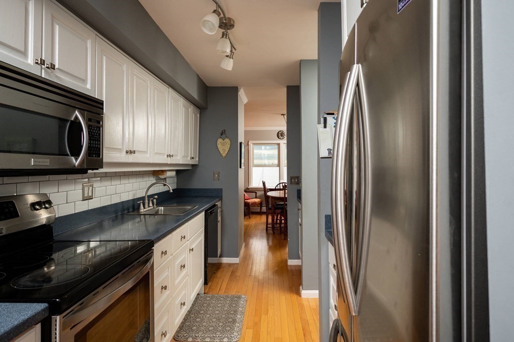 12 Spinnaker Hill Lane, Unit 12 Hull, MA 02045 - Photo 23 of 39 a kitchen with stainless steel appliances granite countertop a refrigerator a stove top oven a sink and dishwasher