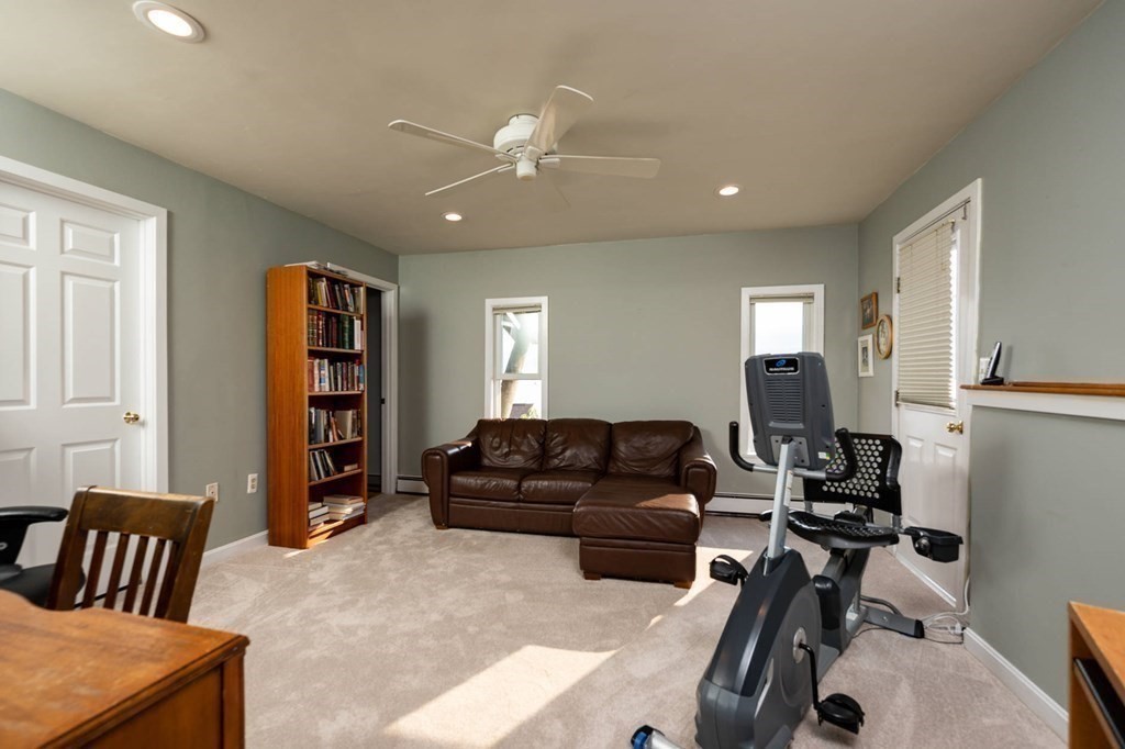 12 Spinnaker Hill Lane, Unit 12 Hull, MA 02045 - Photo 27 of 39 a living room with furniture and a book shelf