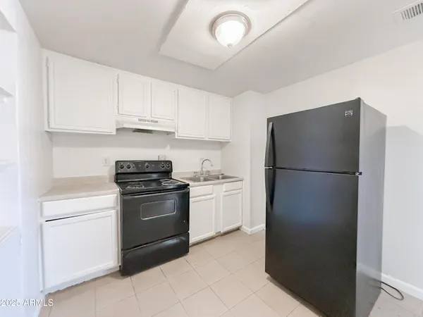 a kitchen with a refrigerator sink and cabinets