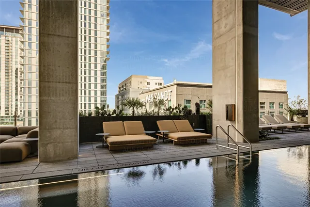 a living room with couches and a floor to ceiling window next to a building