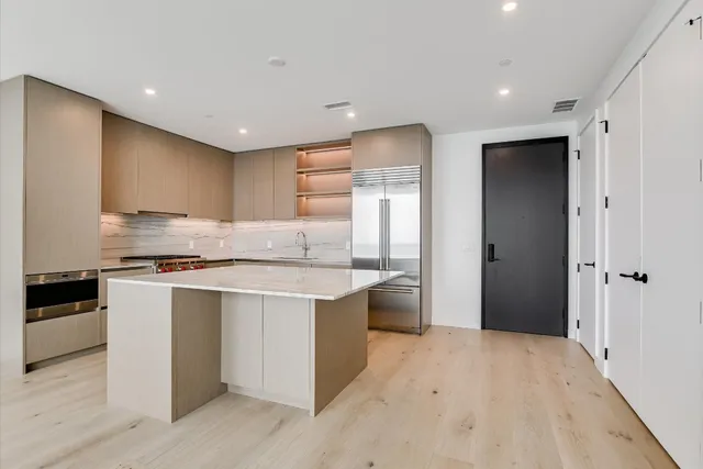 a kitchen with stainless steel appliances granite countertop a refrigerator and a sink