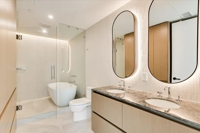 a bathroom with a granite countertop toilet a sink and a mirror