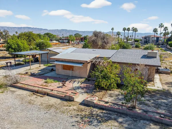 an aerial view of a house with a garden and lake view