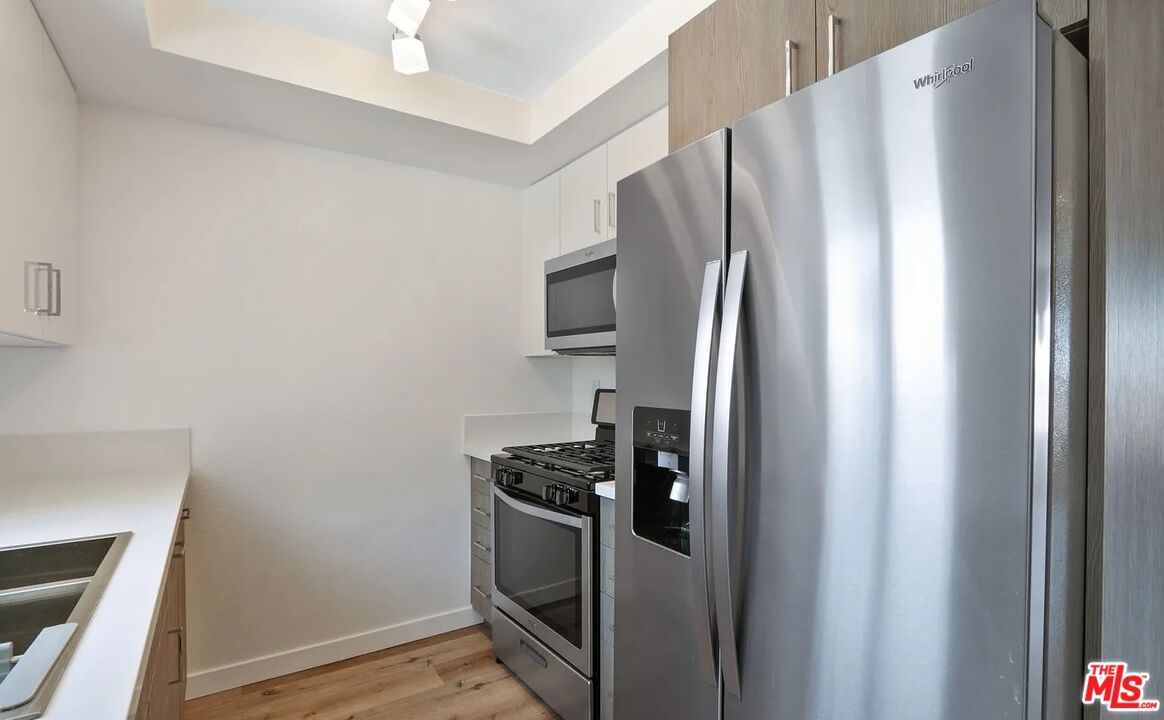 110 South Eucalyptus Avenue, Unit 5 Inglewood, CA 90301 - Photo 5 of 12 a kitchen with metallic refrigerator freezer and a stove