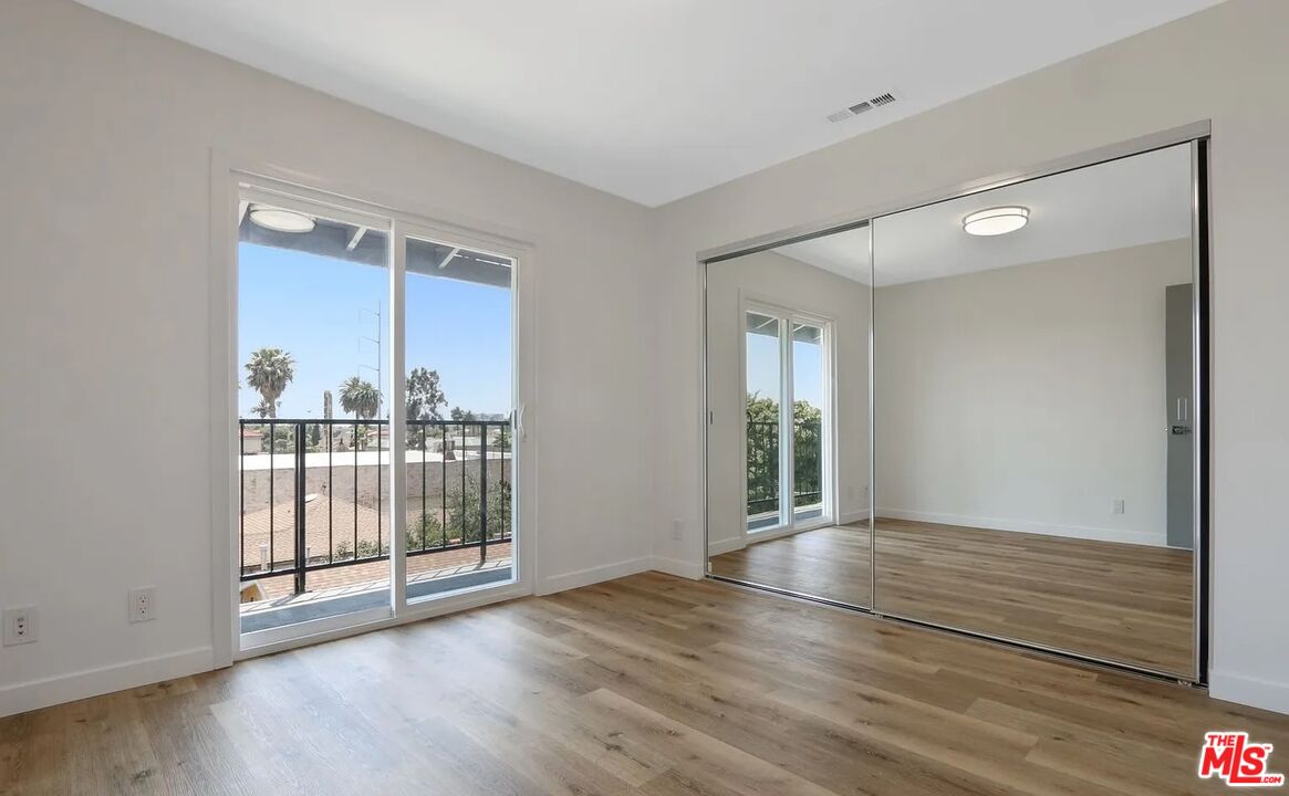 110 South Eucalyptus Avenue, Unit 5 Inglewood, CA 90301 - Photo 8 of 12 a view of an empty room with wooden floor and a window