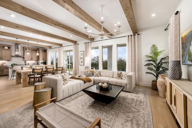 a living room with furniture large window and wooden floor