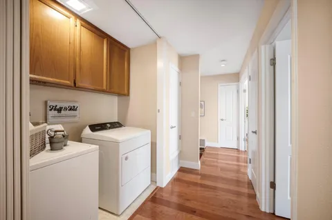 a view of a kitchen with fridge and wooden floor