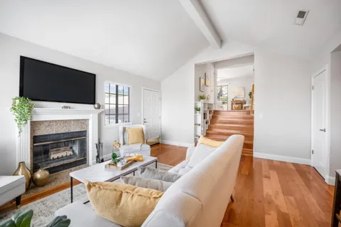 a living room with furniture a fireplace and a flat screen tv