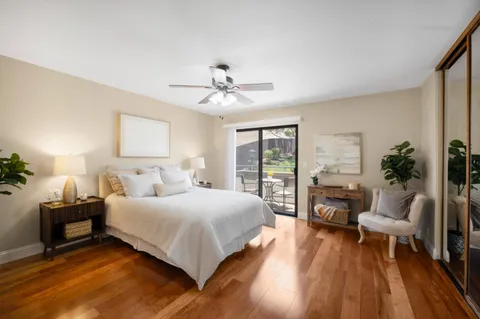 a bedroom with a bed a couch and a potted plant on the dresser