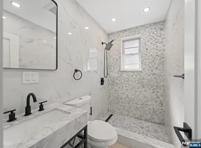 a bathroom with a toilet a sink and mirror