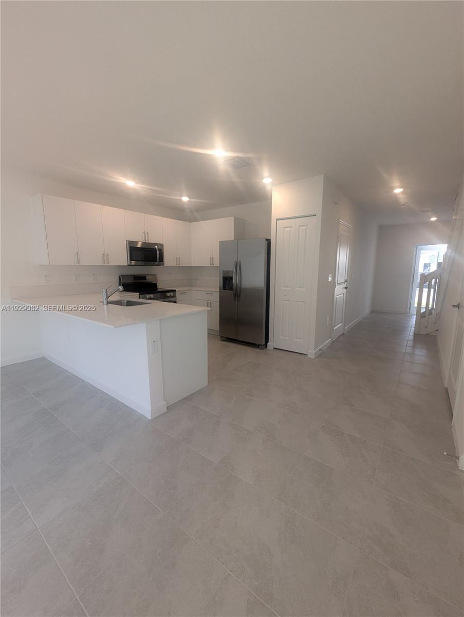 5180 Southwest 37th Street, Unit 5180 Hollywood, FL 33023 - Photo 11 of 25 a view of a kitchen with a sink and a refrigerator