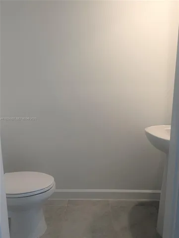 a white toilet sitting next to a shower