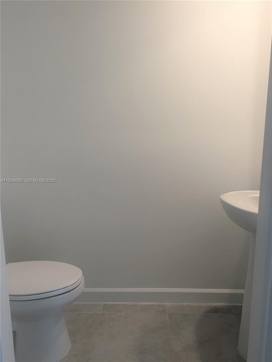5180 Southwest 37th Street, Unit 5180 Hollywood, FL 33023 - Photo 12 of 25 a white toilet sitting next to a shower