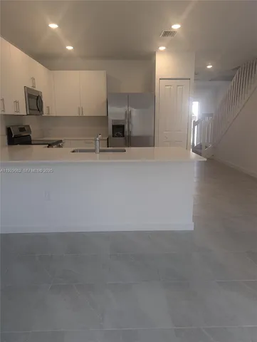 a view of a kitchen with stainless steel appliances cabinets