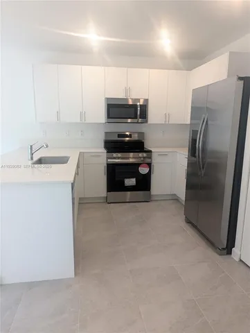 a kitchen with a refrigerator and a stove