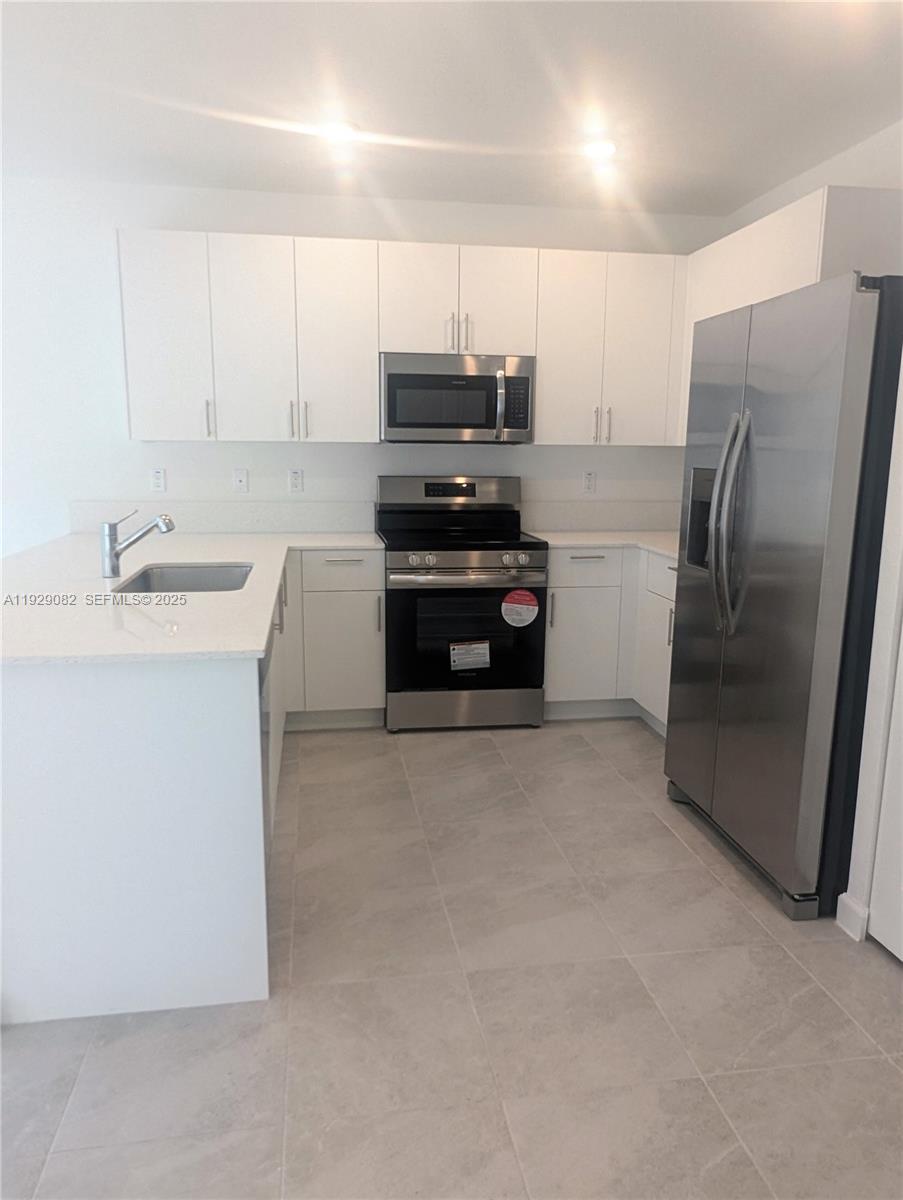 5180 Southwest 37th Street, Unit 5180 Hollywood, FL 33023 - Photo 9 of 25 a kitchen with a refrigerator and a stove