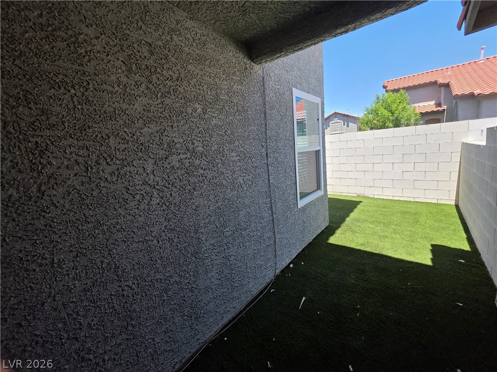 2275 Ramsgate Drive Henderson, NV 89074 - Photo 17 of 84 A well-maintained outdoor space with synthetic turf, bordered by a privacy wall.