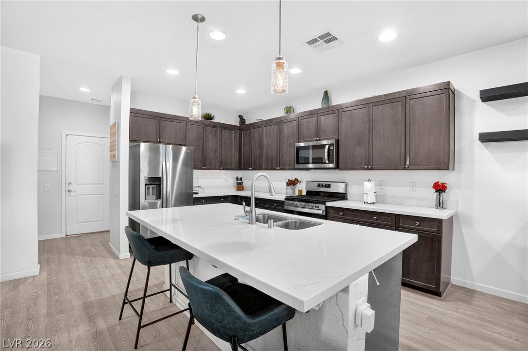6281 Angora Peak Lane Las Vegas, NV 89115 - Photo 12 of 34 Bright and airy, this kitchen features rich cabinetry, stainless steel appliances, and a central island with bar seating.