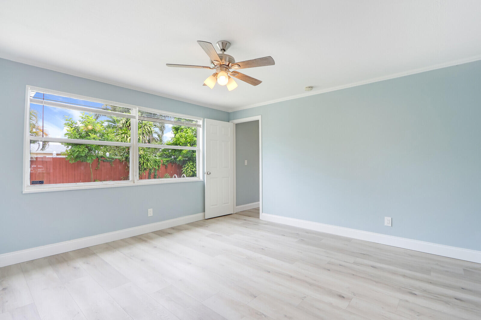 3852 Gull Road Palm Beach Gardens, FL 33410 - Photo 11 of 30 a view of an empty room with wooden floor and a window
