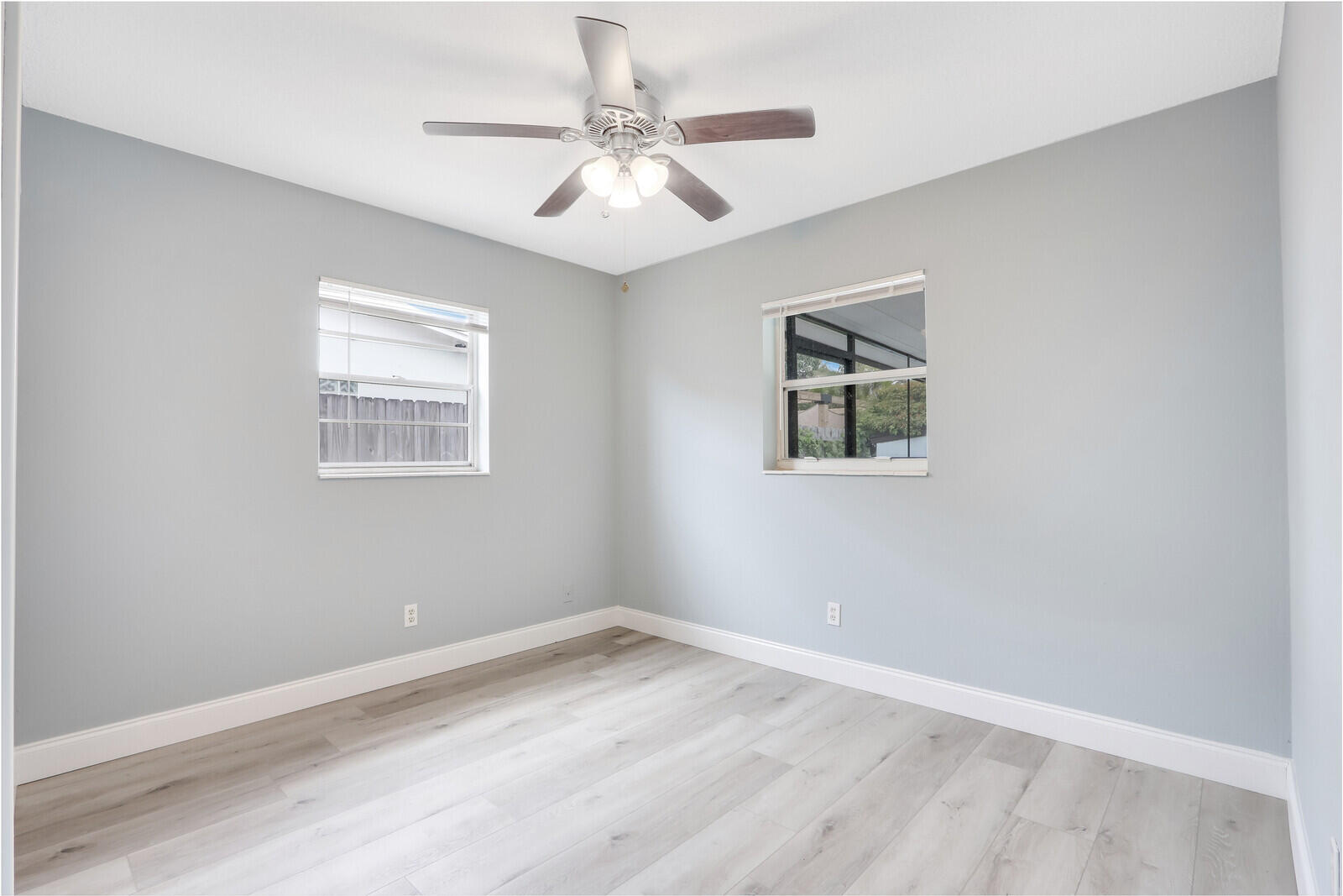 3852 Gull Road Palm Beach Gardens, FL 33410 - Photo 18 of 30 an empty room with wooden floor and windows