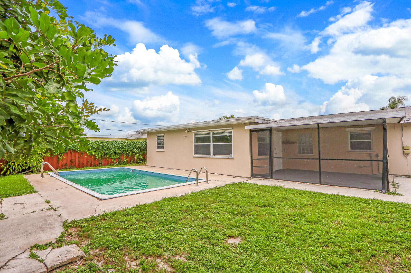 3852 Gull Road Palm Beach Gardens, FL 33410 - Photo 26 of 30 a view of a backyard with table and chairs and wooden fence