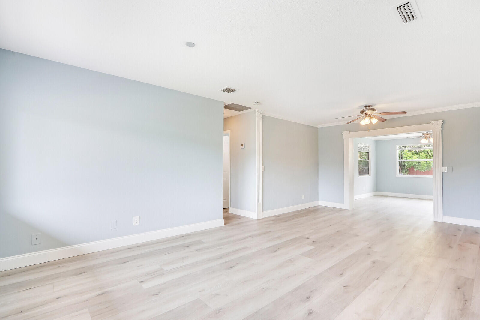 3852 Gull Road Palm Beach Gardens, FL 33410 - Photo 3 of 30 a view of an empty room with wooden floor and a window