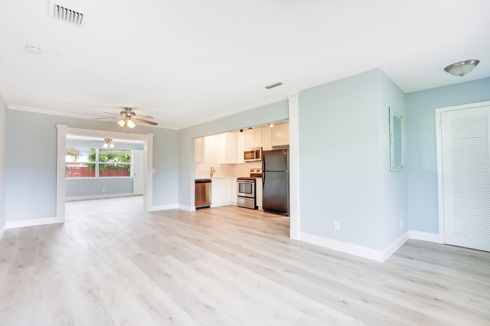 3852 Gull Road Palm Beach Gardens, FL 33410 - Photo 4 of 30 a view of empty room with wooden floor and windows