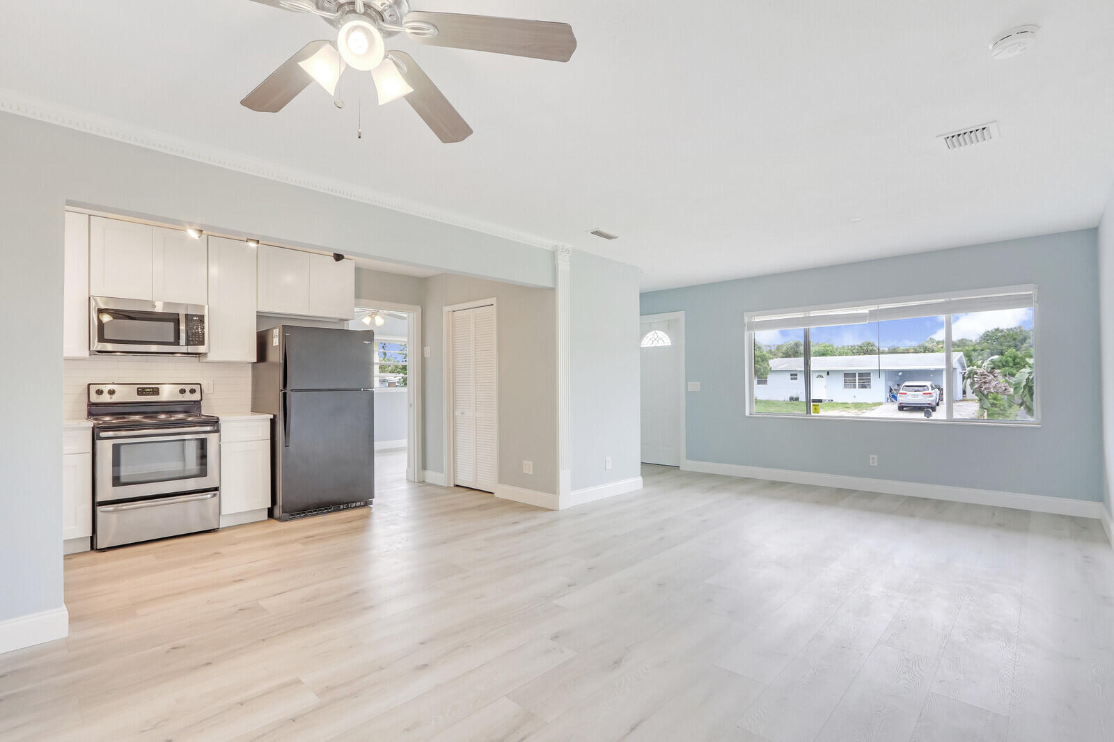 3852 Gull Road Palm Beach Gardens, FL 33410 - Photo 5 of 30 an empty room with windows and ceiling fan