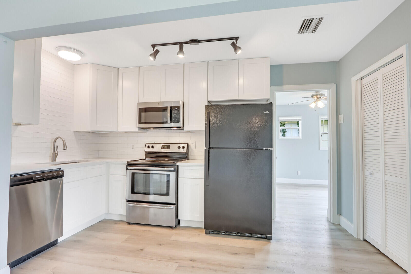 3852 Gull Road Palm Beach Gardens, FL 33410 - Photo 7 of 30 a kitchen with stainless steel appliances granite countertop a refrigerator a stove a sink and a microwave